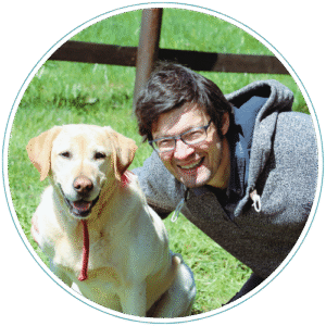 A neurodivergent man plays with his dog in a park, feeling comfortable with herself thanks to neurodivergent counseling.