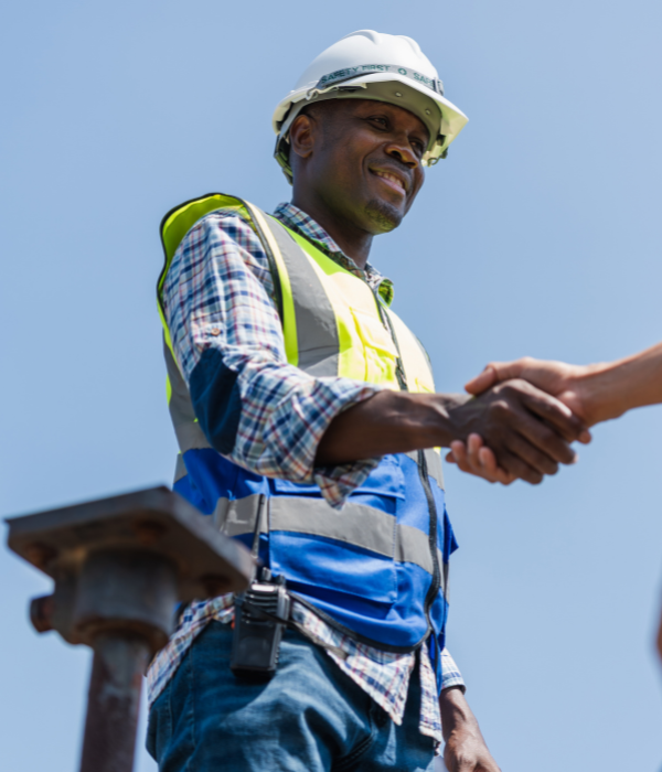 A man in a hardhat working in construction shakes hands with another man. Online counseling works around your schedule.